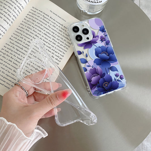 Hand holding a floral phone case next to an open book on a table.